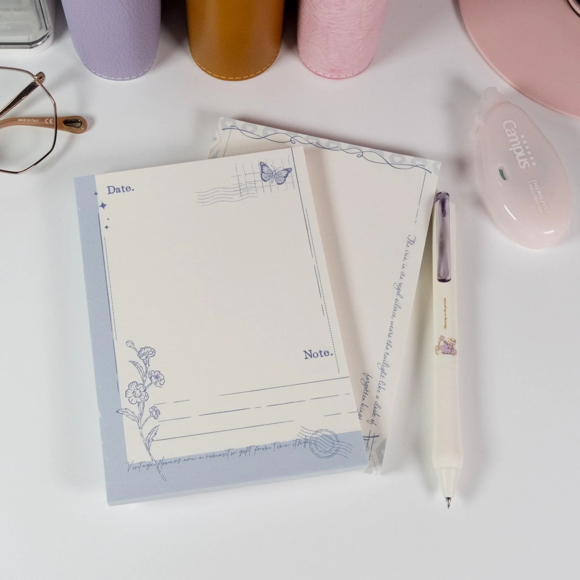 Butterfly and Flower A6 notepad placed on desk with pen and soft lighting - Miouva