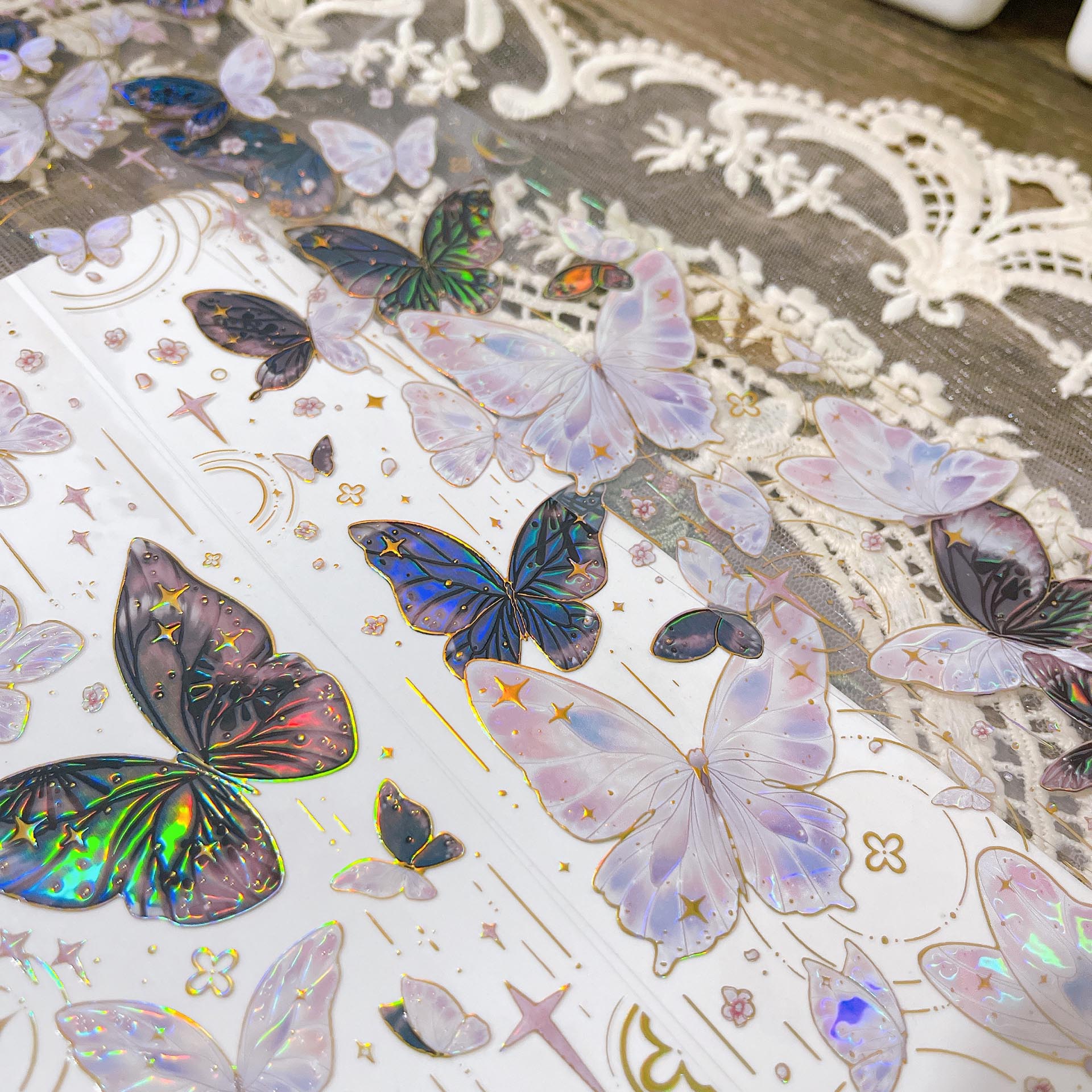 Close-up of iridescent butterfly designs with soft pink and blue reflections on transparent PET tape - Miouva