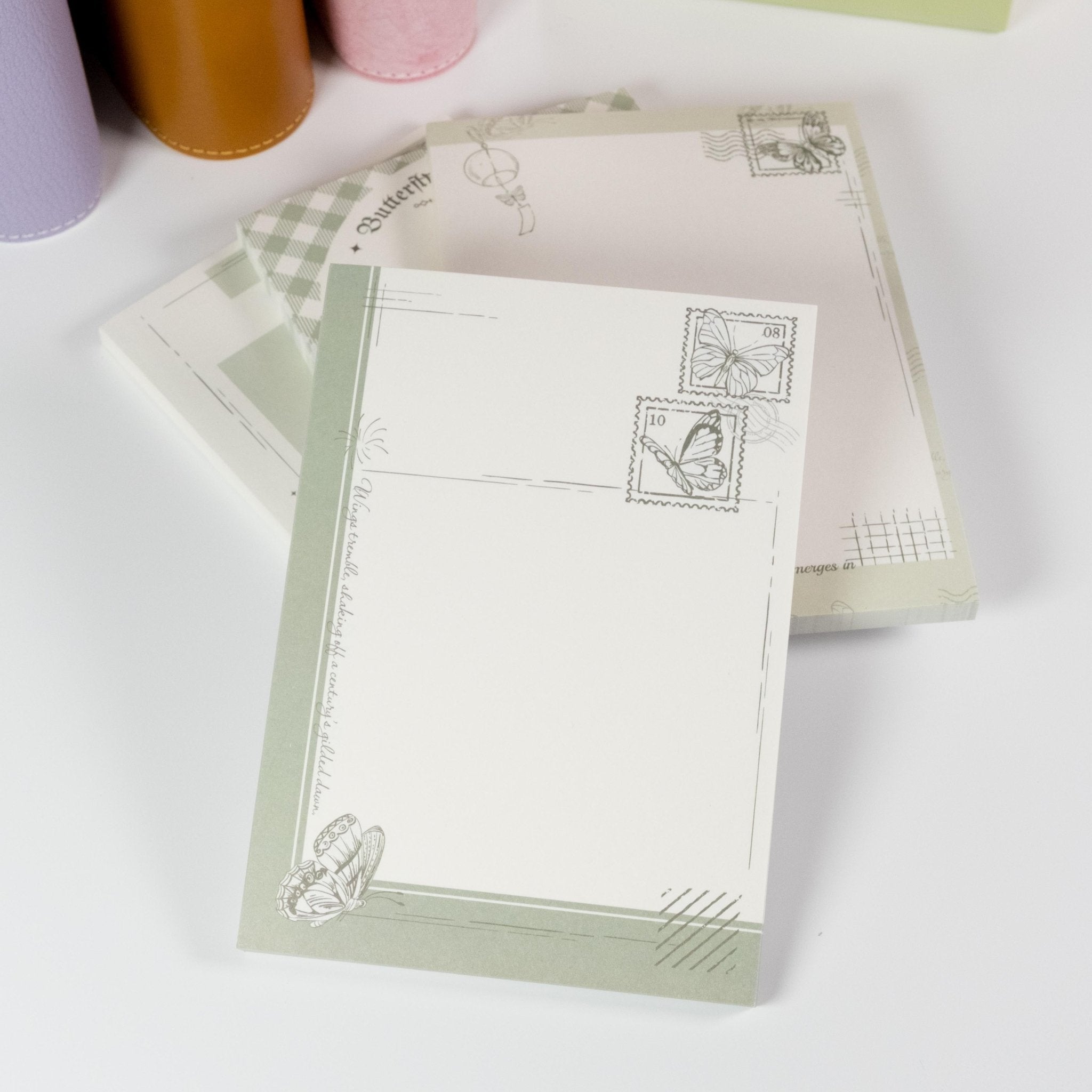 Stack of Butterfly Dreams notepads showing delicate postal-style layouts - Miouva
