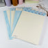 Summer Beach B5 notepads by Shuhui with blue and cream pages on a white desk - Miouva
