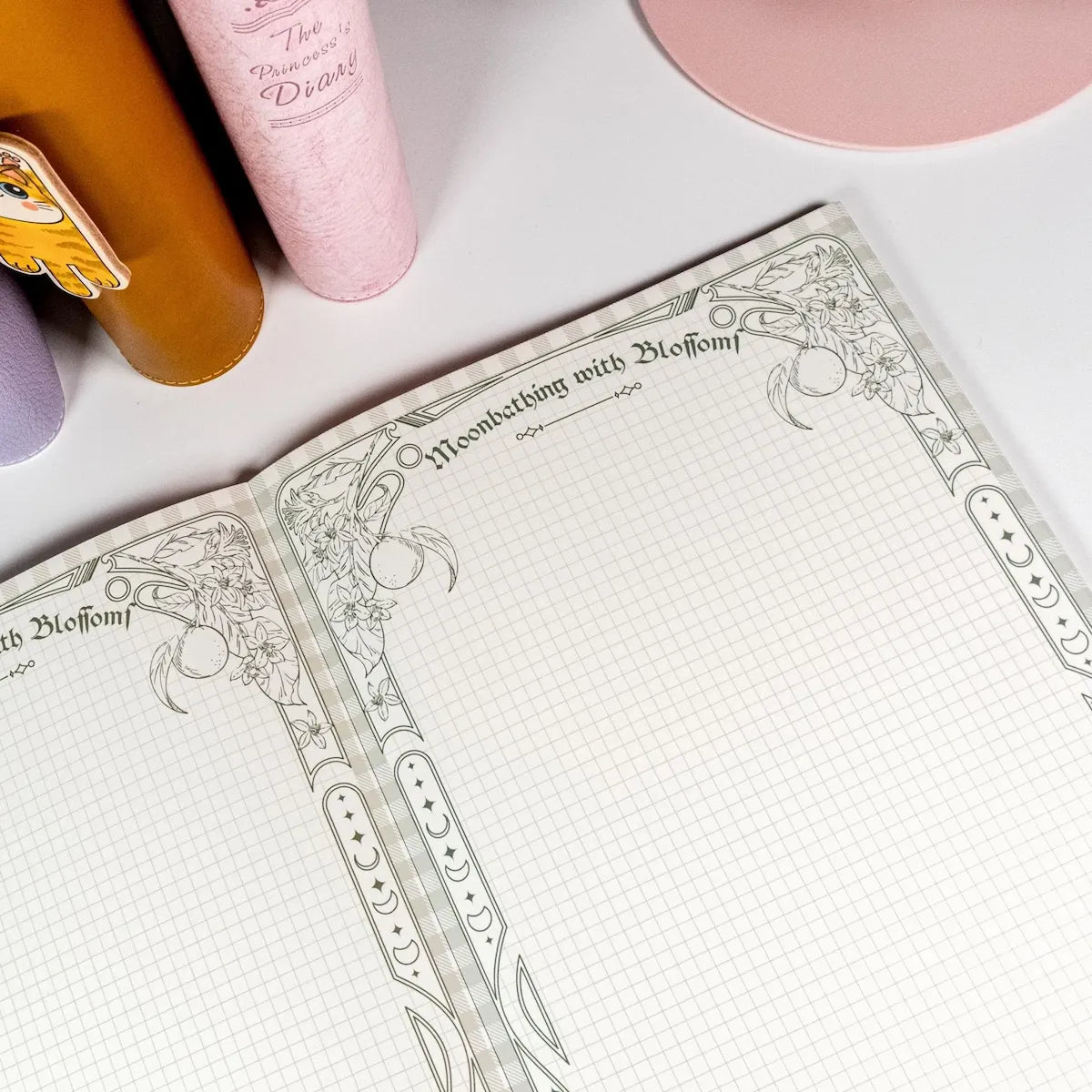 Horizontal B5 notepad open showing lined page with citrus blossom frame - Miouva